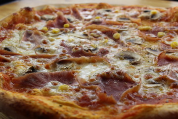 Calabrian pizza with ham, mushroom and cheese on a white plate.