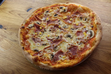 Calabrian pizza with ham, mushroom and cheese on a white plate.