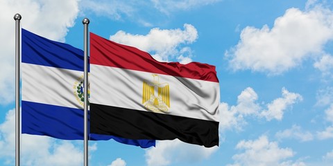 El Salvador and Egypt flag waving in the wind against white cloudy blue sky together. Diplomacy concept, international relations.