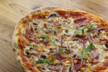 Calabrian pizza with ham, mushroom and cheese on a white plate.