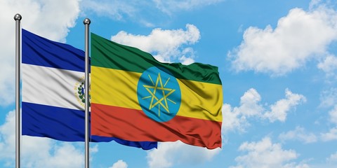 El Salvador and Ethiopia flag waving in the wind against white cloudy blue sky together. Diplomacy concept, international relations.