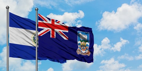 El Salvador and Falkland Islands flag waving in the wind against white cloudy blue sky together....