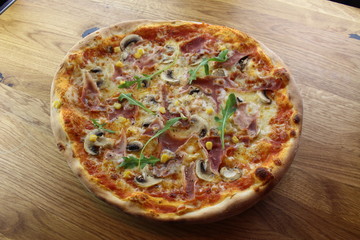 Calabrian pizza with ham, mushroom and cheese on a white plate.