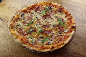 Calabrian pizza with ham, mushroom and cheese on a white plate.