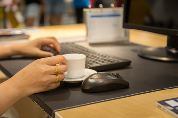 Fototapeta na wymiar Woman hand holdding coffee cup with working table