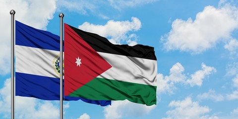 El Salvador and Jordan flag waving in the wind against white cloudy blue sky together. Diplomacy concept, international relations.
