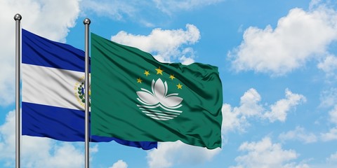 El Salvador and Macao flag waving in the wind against white cloudy blue sky together. Diplomacy...