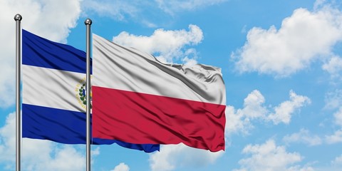El Salvador and Poland flag waving in the wind against white cloudy blue sky together. Diplomacy concept, international relations.