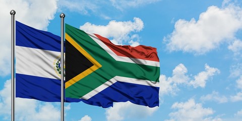El Salvador and South Africa flag waving in the wind against white cloudy blue sky together. Diplomacy concept, international relations.