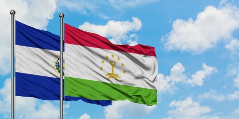 El Salvador and Tajikistan flag waving in the wind against white cloudy blue sky together. Diplomacy concept, international relations.