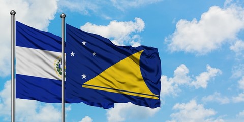 El Salvador and Tokelau flag waving in the wind against white cloudy blue sky together. Diplomacy concept, international relations.