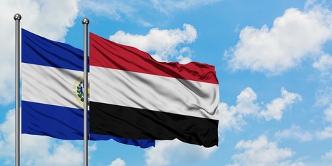 El Salvador and Yemen flag waving in the wind against white cloudy blue sky together. Diplomacy concept, international relations.