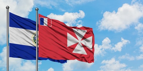 El Salvador and Wallis And Futuna flag waving in the wind against white cloudy blue sky together. Diplomacy concept, international relations.
