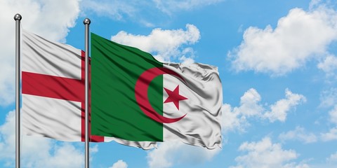 England and Algeria flag waving in the wind against white cloudy blue sky together. Diplomacy...