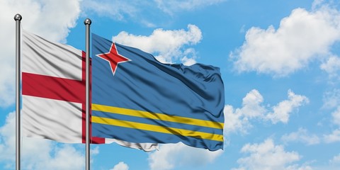 England and Aruba flag waving in the wind against white cloudy blue sky together. Diplomacy concept, international relations.