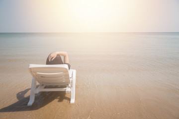 Fototapeta na wymiar Vacation on tropical beach Woman rest on the beach bed