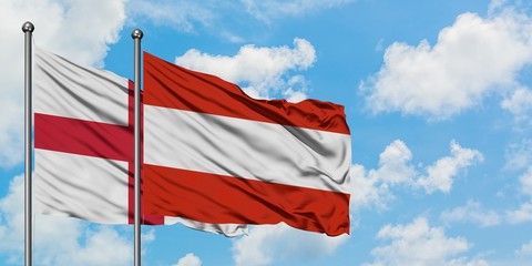 England and Austria flag waving in the wind against white cloudy blue sky together. Diplomacy concept, international relations.