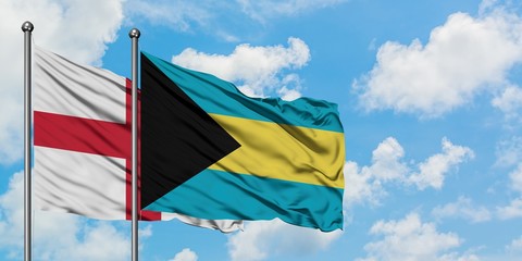 England and Bahamas flag waving in the wind against white cloudy blue sky together. Diplomacy concept, international relations.