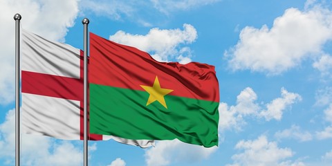 England and Burkina Faso flag waving in the wind against white cloudy blue sky together. Diplomacy concept, international relations.