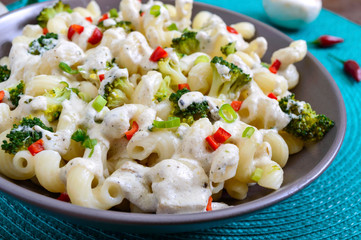 Cavatappi pasta with broccoli, red pepper and cream sauce in a bowl. Vegetarian dish. Delicious healthy food. Proper nutrition.