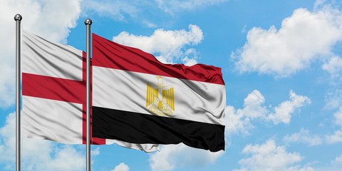 England and Egypt flag waving in the wind against white cloudy blue sky together. Diplomacy concept, international relations.