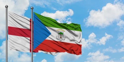 England and Equatorial Guinea flag waving in the wind against white cloudy blue sky together. Diplomacy concept, international relations.