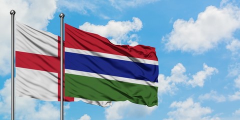 England and Gambia flag waving in the wind against white cloudy blue sky together. Diplomacy concept, international relations.