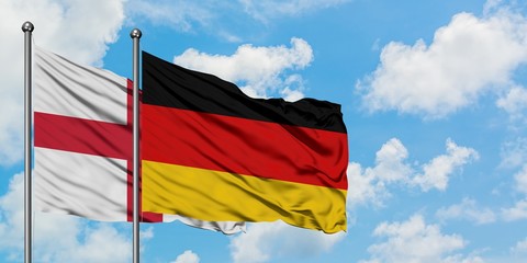 England and Germany flag waving in the wind against white cloudy blue sky together. Diplomacy concept, international relations.