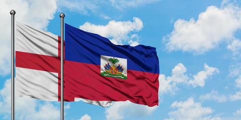 England and Haiti flag waving in the wind against white cloudy blue sky together. Diplomacy...