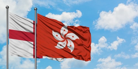 England and Hong Kong flag waving in the wind against white cloudy blue sky together. Diplomacy concept, international relations.