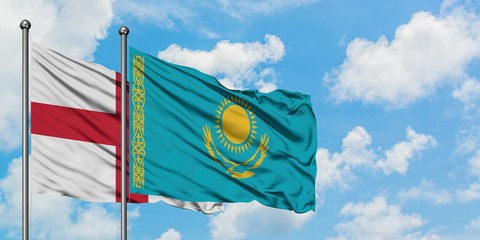 England and Kazakhstan flag waving in the wind against white cloudy blue sky together. Diplomacy...