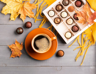 Cup of black coffee box of chocolates on an autumn background. Selective focus. Copy space. Top view flat layout.