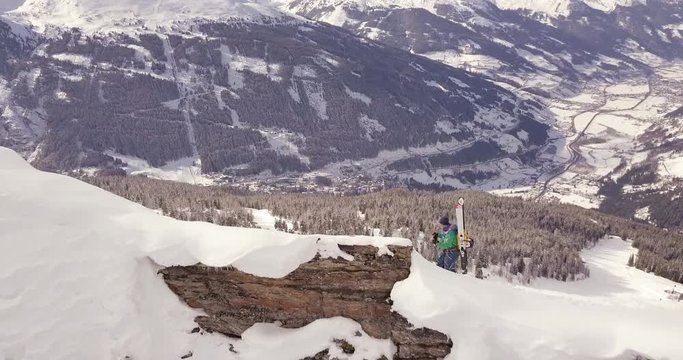 Aerial drone shot of a male freeride skier hiking and walking on a mountain ridge in Salzburg Austria Gastein
