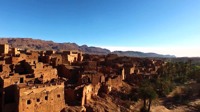 Aerial view of a beautiful abandoned small village with palm trees around in Tinghir, Morocco. Africa, Moroccan Sahara desert