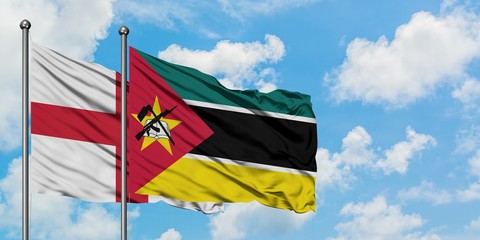 England and Mozambique flag waving in the wind against white cloudy blue sky together. Diplomacy...