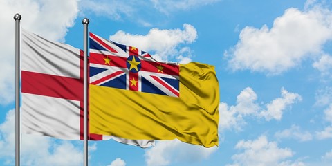 England and Niue flag waving in the wind against white cloudy blue sky together. Diplomacy concept, international relations.