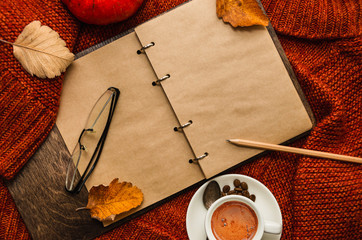 A diary, cup of coffee, fallen leaves. Plans for november. Autumn concept. Flat lay, top view. Copy space