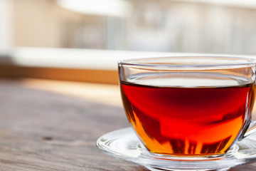Hot cup of tea on wooden rustic table close up