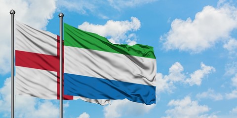 England and Sierra Leone flag waving in the wind against white cloudy blue sky together. Diplomacy concept, international relations.