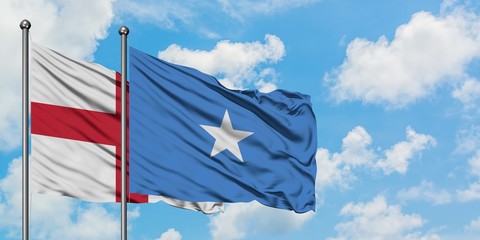England and Somalia flag waving in the wind against white cloudy blue sky together. Diplomacy concept, international relations.