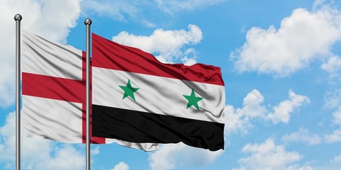 England and Syria flag waving in the wind against white cloudy blue sky together. Diplomacy concept, international relations.