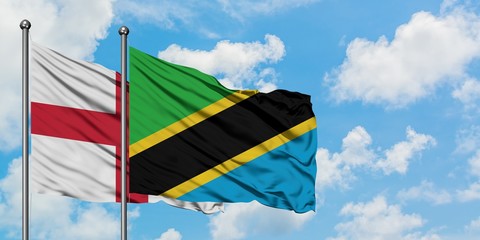 England and Tanzania flag waving in the wind against white cloudy blue sky together. Diplomacy concept, international relations.