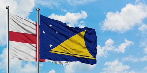 England and Tokelau flag waving in the wind against white cloudy blue sky together. Diplomacy concept, international relations.