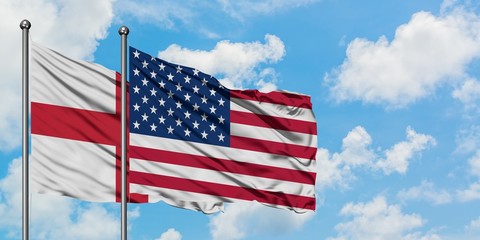 England and United States flag waving in the wind against white cloudy blue sky together. Diplomacy concept, international relations.