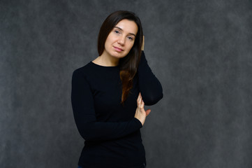 Portrait of an adult woman without makeup with clean skin, with long brown hair over her face on a...