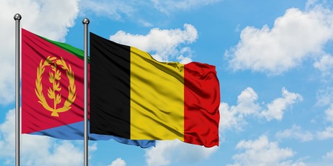 Eritrea and Belgium flag waving in the wind against white cloudy blue sky together. Diplomacy concept, international relations.
