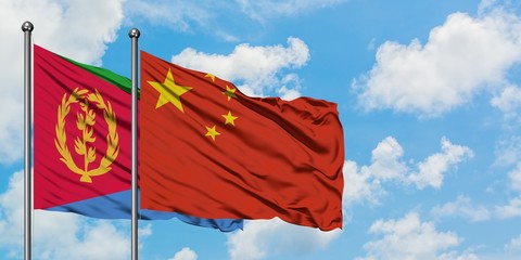 Eritrea and China flag waving in the wind against white cloudy blue sky together. Diplomacy concept, international relations.