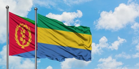 Eritrea and Gabon flag waving in the wind against white cloudy blue sky together. Diplomacy concept, international relations.