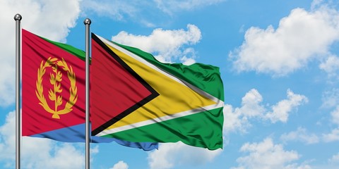 Eritrea and Guyana flag waving in the wind against white cloudy blue sky together. Diplomacy...