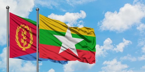 Eritrea and Myanmar flag waving in the wind against white cloudy blue sky together. Diplomacy...